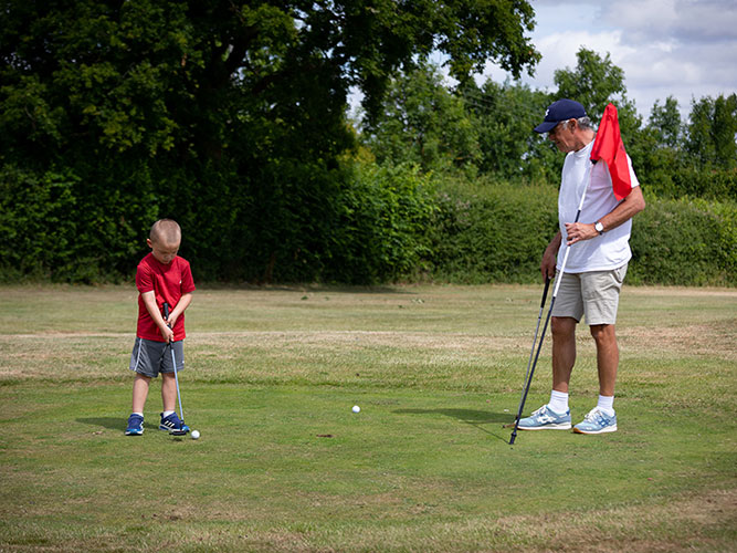 man and boy playing pitch and putt